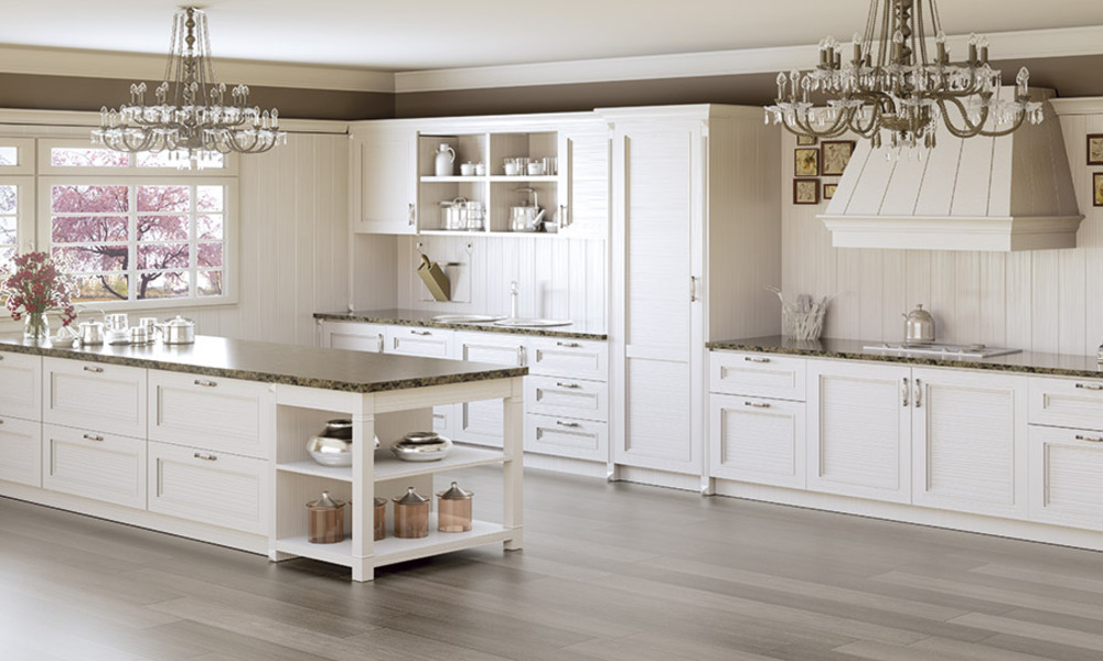 O estilo requintado dos candeeiros assim como o pormenor do acabamento do sóculo e boiserie do armário central que se encontra na vertical são os detalhes que marcam a diferença nesta cozinha em madeira. cozinha em madeira
